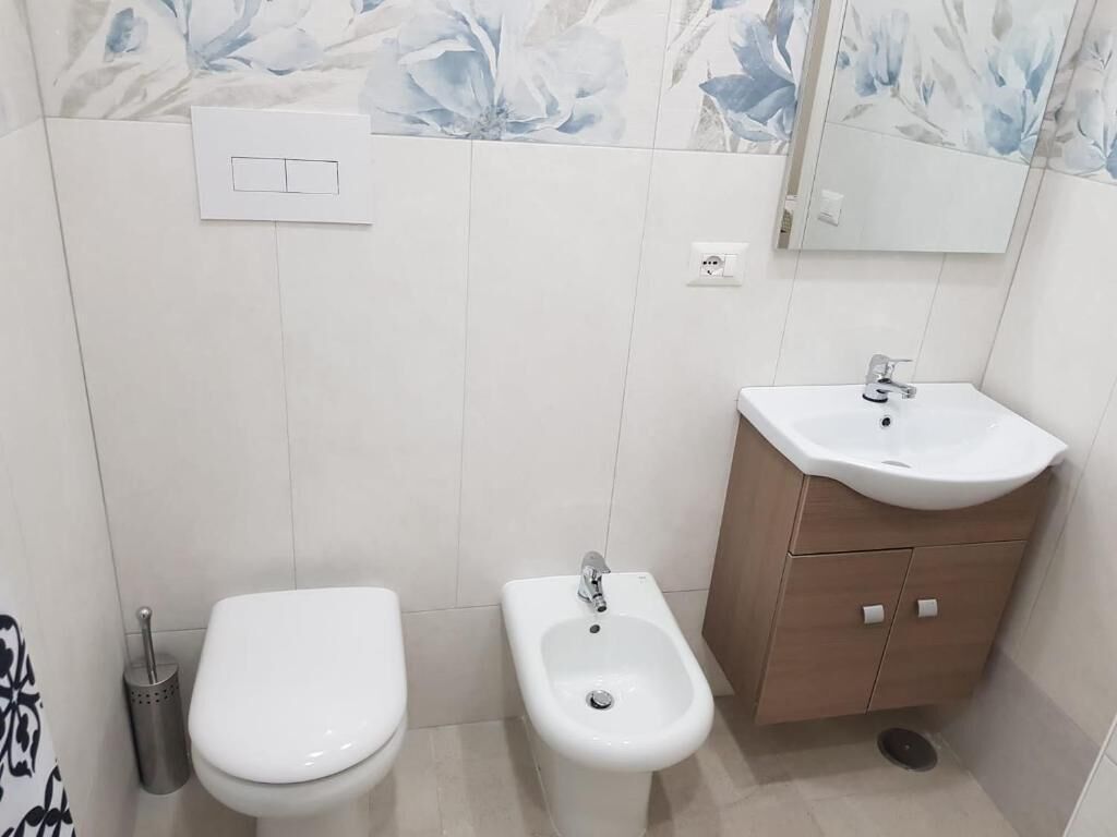 Une salle de bain équipée de toilettes, d’un bidet et d’un lavabo.