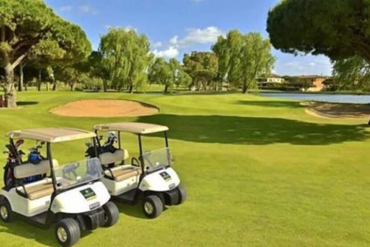 Un campo de golf con dos carritos de golf estacionados en el green.