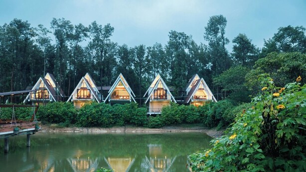 Cabañas de techo triangular con un cuerpo de agua al frente.