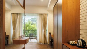 Una cocina moderna con encimera de madera, un hervidor y una zona de comedor con mesa y sillas.