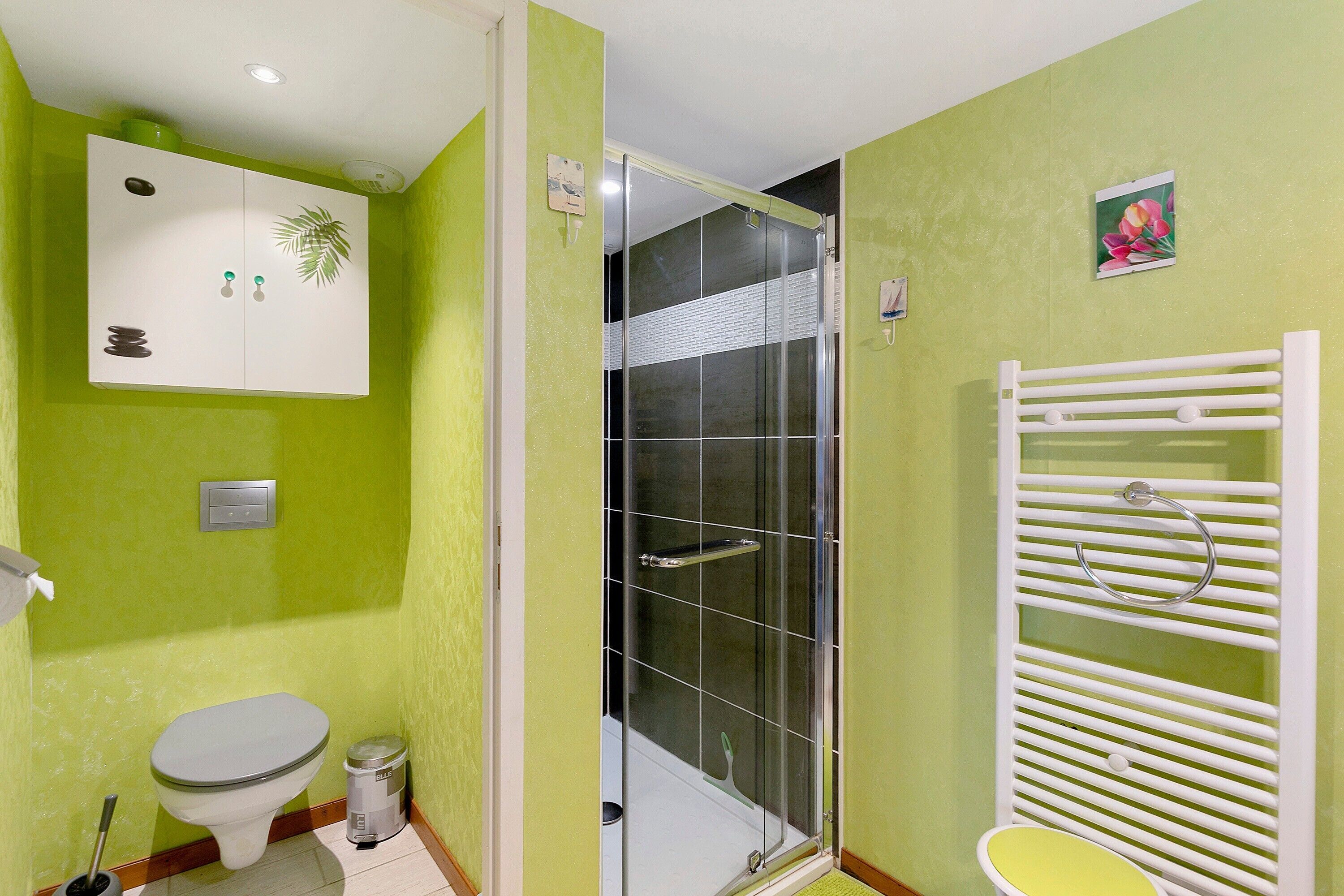A bathroom with a toilet, a shower, and a sink.