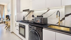 Eine moderne Küche mit Einbauofen, Geschirrspüler und Kaffeemaschine.