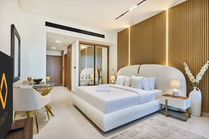 A modern hotel room with a large bed, bedside tables, a seating area, and a view of the hallway. - Stylish Studio with Dubai Canal & Skyline Views (Dubai)