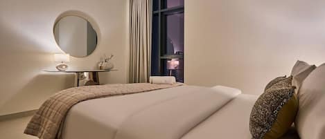 A hotel room with a bed, bedside table, lamp, and a large window with curtains.