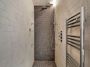 A narrow shower area with a herringbone tile pattern on the walls and floor. - Riverside Cottage With Estuary Views (Fowey)