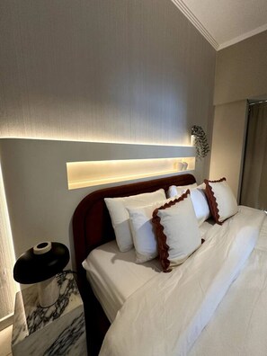 A hotel room with a bed, a bedside table, and a wall-mounted light fixture. - Stunning 1-Bedroom Apartment | Full Marina View (Dubai)