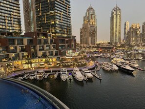 A marina with multiple yachts docked, surrounded by high-rise buildings and a well-lit waterfront area. - Stunning 1-Bedroom Apartment | Full Marina View (Dubai)