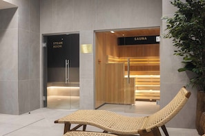Ein Spa-Raum mit einer hölzernen Bank, einer finnischen Sauna und einem Dampfbad.