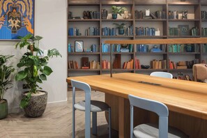 Eine Bibliothek mit Bücherregalen, einem Holztisch und zwei Stühlen.