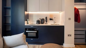 Una cocina moderna con electrodomésticos integrados, una encimera y un tendedero.