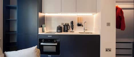 A modern kitchen with built-in appliances, a countertop, and a hanging rack.