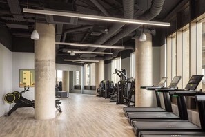 A gym with treadmills, weight machines, and a rowing machine. - Accessible Studio | Long Stay Ideal | StayCozy (London)