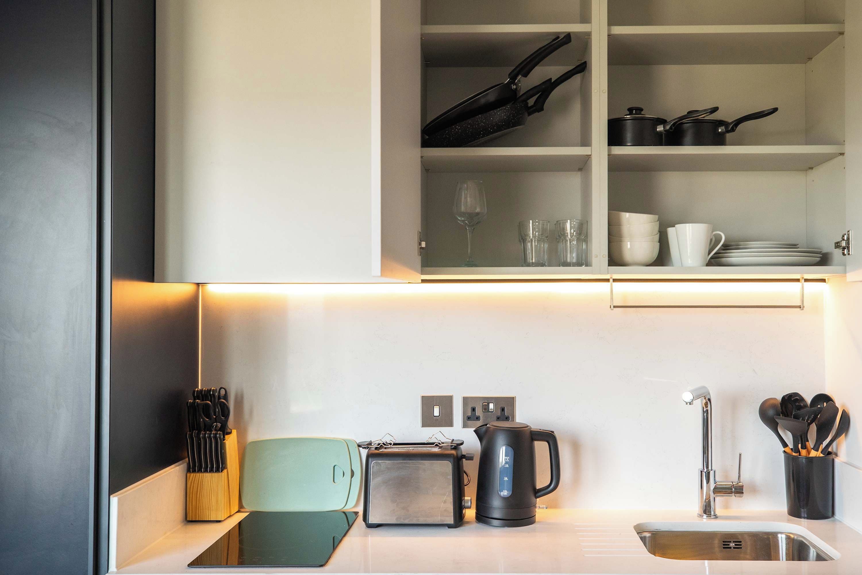 A modern kitchen with a toaster, kettle, and knife block.