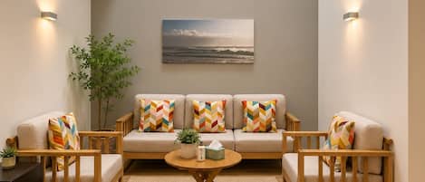 A cozy living room with a sofa set, a coffee table, and a painting on the wall.