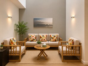 A cozy living room with a sofa set, a coffee table, and a painting on the wall.