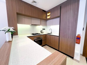 Eine moderne Küche mit Holzschränken, einem Gasherd, einem Backofen und einem Spülbecken.