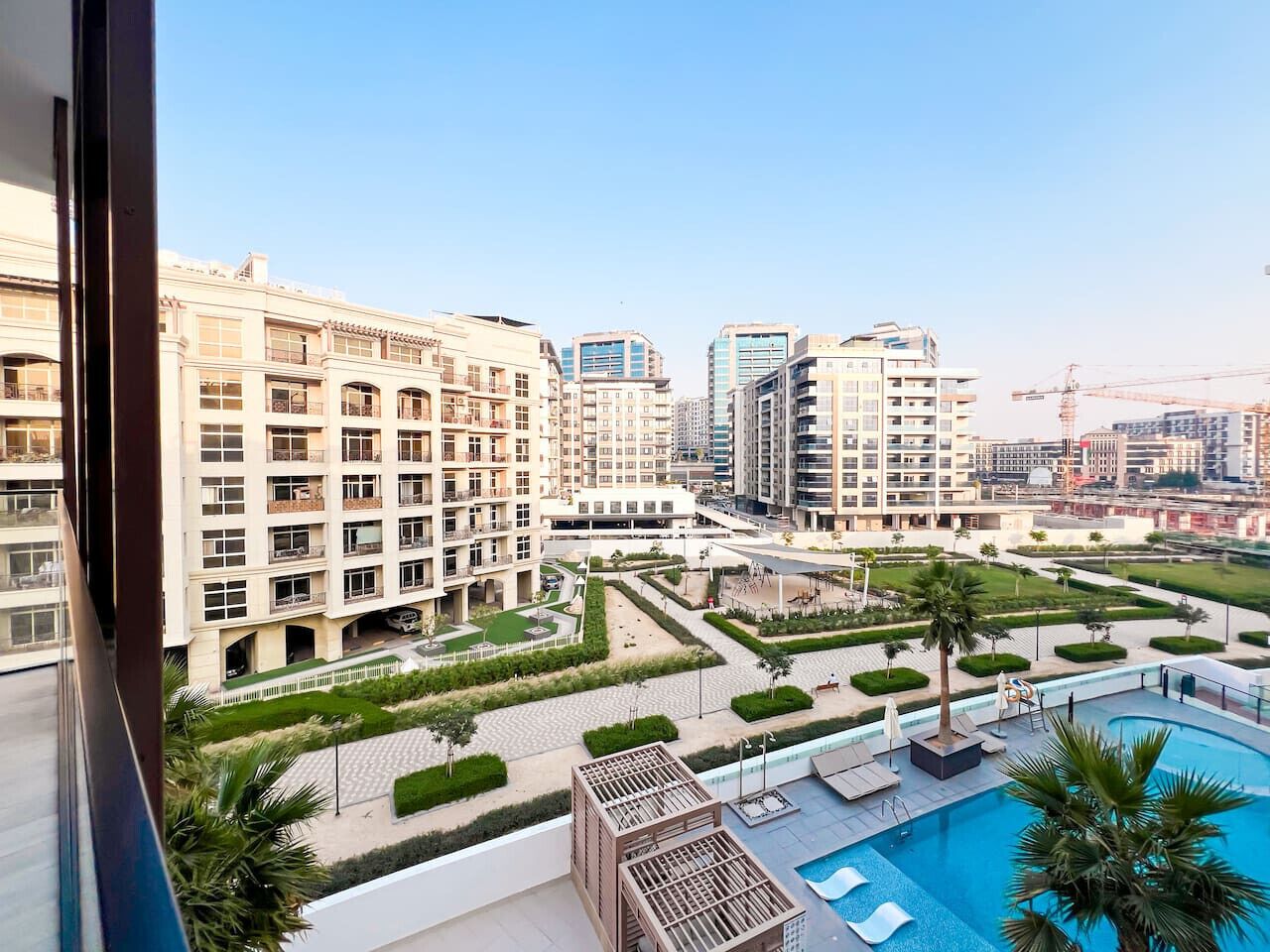 Un edificio residencial con varios balcones, piscina y un patio ajardinado.