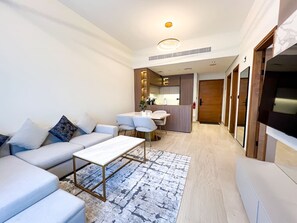 Ein modernes Wohnzimmer mit einer Sofagarnitur, einem Couchtisch und einem Essbereich mit Stühlen.