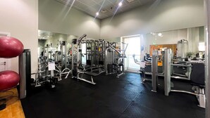 A gym with various exercise machines, a black rubber floor, and a door leading to another room. - Stunning 2BR In Dubai Marina With Amazing views (Dubai)