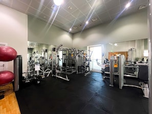 A gym with various exercise machines, a black rubber floor, and a door leading to another room. - Stunning 2BR In Dubai Marina With Amazing views (Dubai)