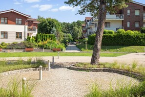 A residential area with multi-story buildings, a paved pathway, and well-maintained greenery. - Belle Époque Suite by the Sea | 2 Bedrooms (Gdańsk)