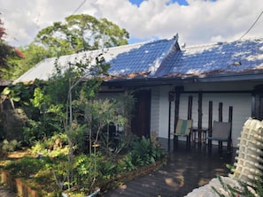 A traditional Japanese house with a tiled roof, a wooden deck, and a garden with various plants. - 清境禾風里湖畔農莊景觀餐廳適合登山騎行與家庭團體寵物友善 (Nantou County)
