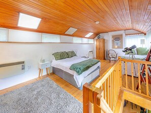 A bedroom with a bed, a nightstand, a wooden ceiling, a window, and a telescope. - Historic Stay Near Knebworth (Knebworth)