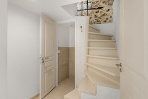 A staircase with a handrail and a door leading to a room. - Apt L’Hospital – In the heart of Tourrettes-sur-Loup (Tourrettes-sur-Loup)