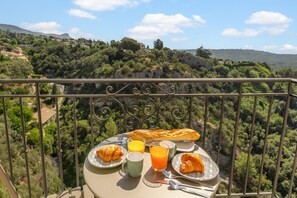 Ein Balkon mit Frühstückstisch, mit Blick auf eine Berglandschaft.