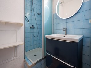 A bathroom with a shower, sink, and mirror. - Air-conditioned apartment with a garage and Wi-Fi (Le Grau-du-Roi)