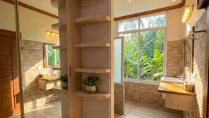A modern bathroom with a wooden vanity, a glass shower enclosure, and a view of greenery outside. - Srithanu Villa (Tambon Ko Pha-ngan)