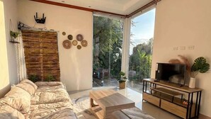 A modern living room with a sofa, coffee table, and entertainment unit. - Srithanu Villa (Tambon Ko Pha-ngan)