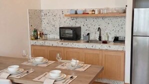 Eine moderne Küche mit Holzschränken, einer eingebauten Mikrowelle und einem Edelstahlkühlschrank.