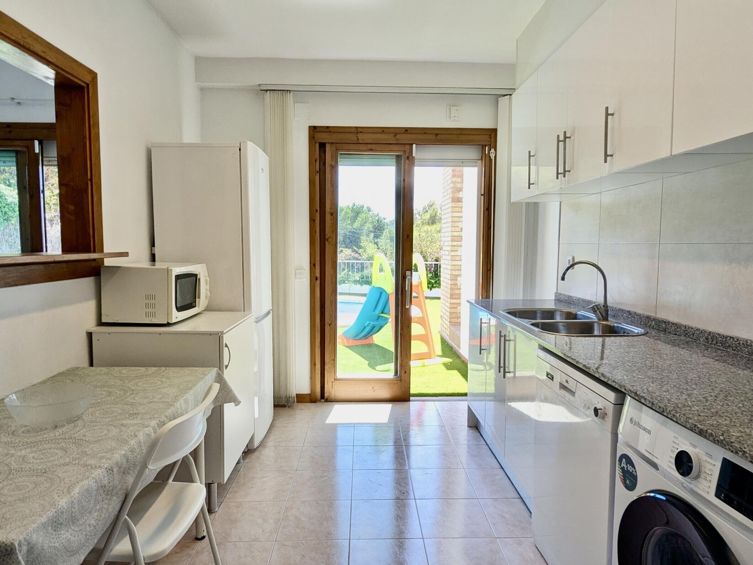 A compact kitchen with a washing machine, a microwave, and a sink.