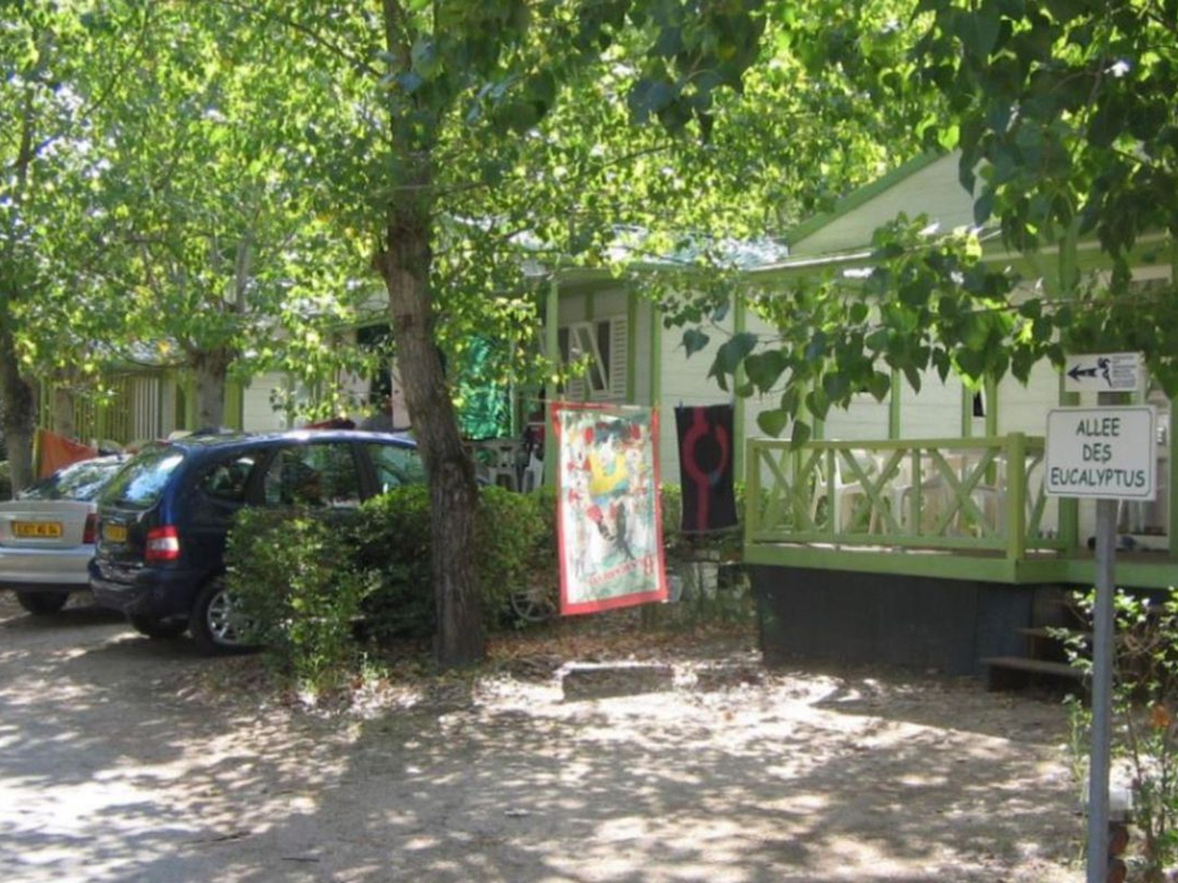 A building with a sign reading 'ALLEE DES EUCALYPTUS' and a parked car.