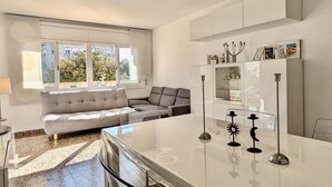 A modern living room with a sofa, a glass coffee table, and a cabinet with decorative items. - Spacious apt, pets welcome, central - 8 guests (Tossa de Mar)