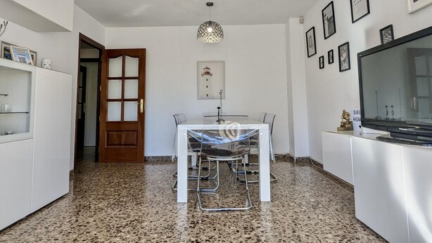 A modern kitchen with a dining table, white cabinetry, granite flooring, and a large flat-screen TV. - Spacious apt, pets welcome, central - 8 guests (Tossa de Mar)