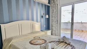 A hotel room with a bed, a nightstand, a window with curtains, and a view of the outside. - Spacious apt, pets welcome, central - 8 guests (Tossa de Mar)