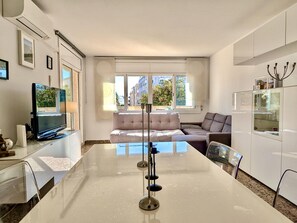 Eine moderne Küche mit Kochinsel, einer Couch und einem Essbereich.
