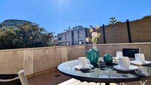 A round glass table with a white teapot, cups, and a vase with flowers on a balcony. - Spacious apt, pets welcome, central - 8 guests (Tossa de Mar)