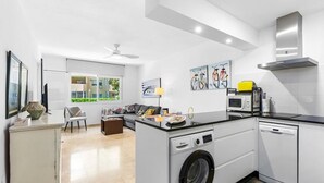 Een moderne keuken met een ingebouwde wasmachine, een magnetron en een kookplaat.