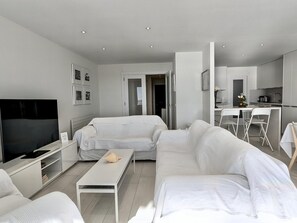 A modern living room with a sofa, a coffee table, and a flat-screen TV. - Spacious apartment, panoramic view - 9 guests (Tossa de Mar)