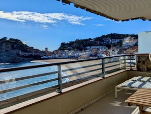 A balcony with a view of a beach and a hillside town. - Spacious apartment, panoramic view - 9 guests (Tossa de Mar)