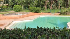 A swimming pool with a clear blue water, surrounded by a stone deck and lush greenery. - Cozy bungalow, pets welcome - 4 guests (ALBITRECCIA)