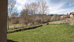 A stone retaining wall with a grassy area and trees in the background. - Cottage, pets allowed, nature in Apinac - 12 guests (Apinac)