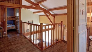 A wooden interior with a high ceiling, a staircase, and a bunk bed. - Cottage, pets allowed, nature in Apinac - 12 guests (Apinac)