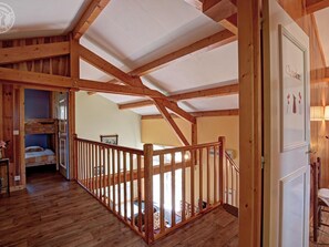 Ein Holzinnenraum mit hohen Decken, einer Treppe und einem Etagenbett.