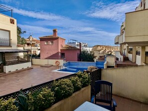 A rooftop terrace with a swimming pool, a chair, and a view of surrounding buildings. - House, sea view - 5 guests (Tossa de Mar)