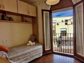 A room with a bed, a small table, a shelf with jars, and a view of the outside. - House, sea view - 5 guests (Tossa de Mar)