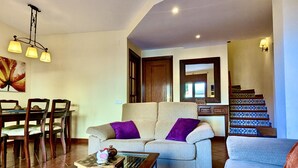 Ein Wohnzimmer mit einer Couch, einem Couchtisch und einem Essbereich mit Stühlen und einem Tisch.